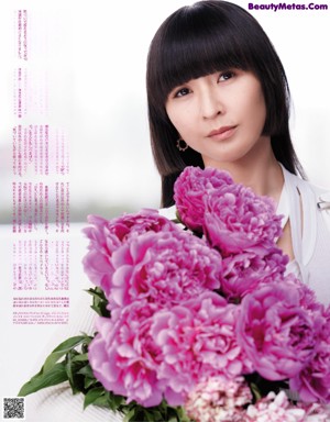 A woman in a white dress holding a bunch of flowers.