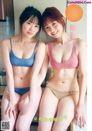 Two young women in bikinis sitting on a kitchen counter.