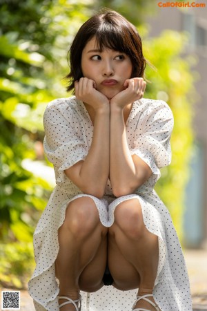 A naked asian woman standing in front of a building.