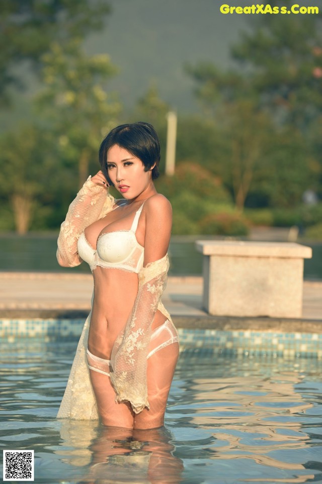 A woman in a white lingerie standing in a pool.