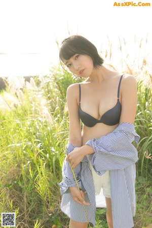 A woman in a blue and white striped shirt and shorts posing for a picture.