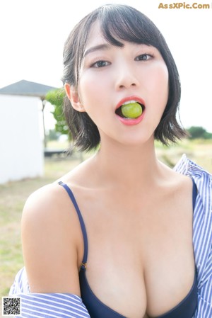 A woman in a blue and white striped shirt and shorts posing for a picture.