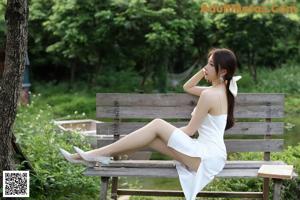 A woman sitting on a bench reading a book.