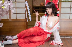 A woman in a red and white kimono posing for a picture.