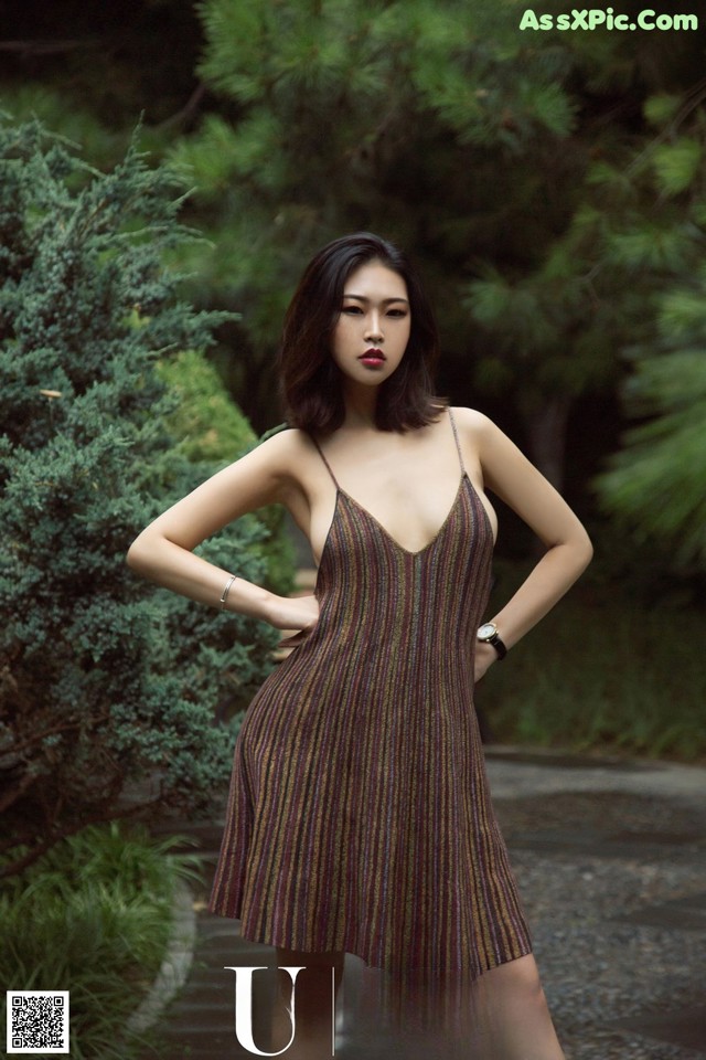 A woman in a brown dress posing for a picture.