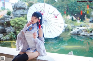 A woman in a blue and white outfit sitting on a ledge.