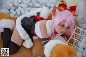 A woman with pink hair sitting on the floor with a stuffed animal.