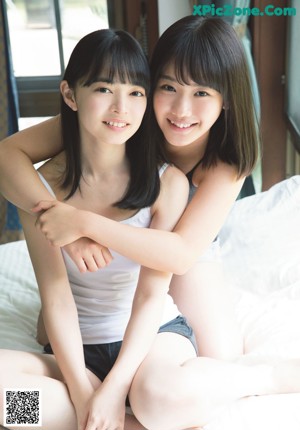 A group of young women sitting on top of a bed.