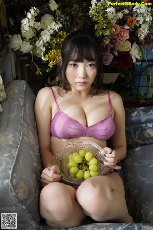 A woman in a pink bikini sitting on a blue chair.