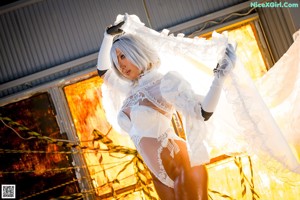 A woman in a wedding dress sitting on a couch.