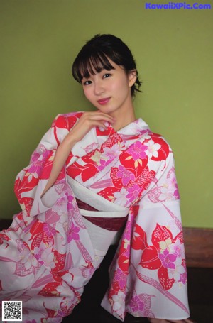 A woman in a blue and white kimono holding a basket.