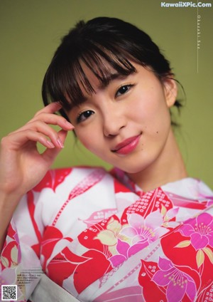 A woman in a blue and white kimono holding a basket.