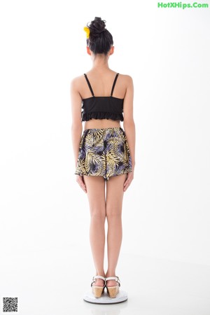 A woman in a black top and a yellow and black skirt.
