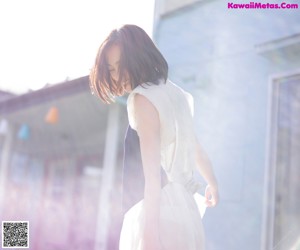 A woman in a white and purple dress posing for a picture.