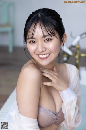A woman in a bathtub with water on her body.