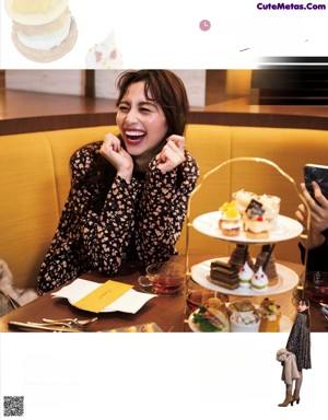 A woman sitting at a table talking on a cell phone.