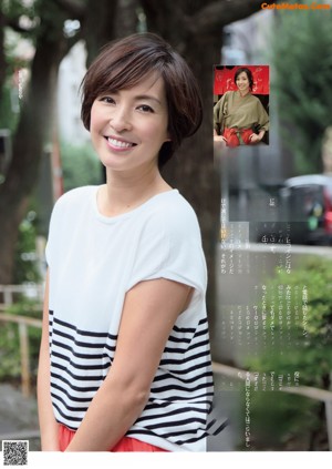 A woman leaning against a wall with her hand on her chin.