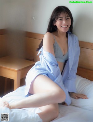 A woman laying on a bed in a blue bra and panties.