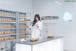 A woman in a white lab coat holding a test tube.