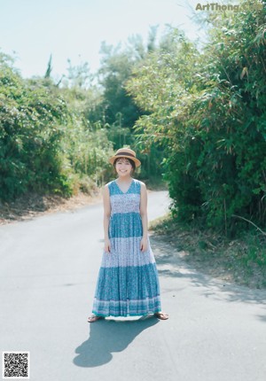 A young woman wearing a straw hat posing for a picture.