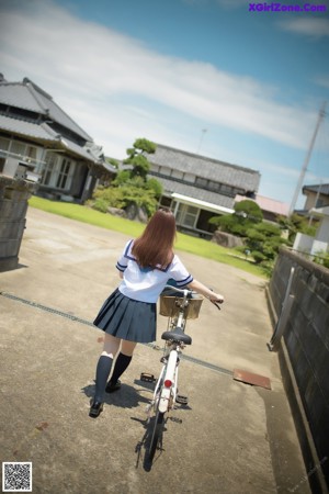 A naked asian woman in a school uniform posing for the camera.