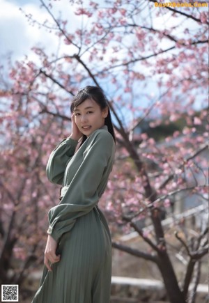 A woman in a green shirt is posing for a picture.