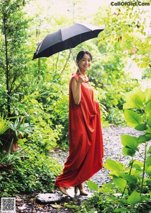 A woman in a red dress looking out of a window.