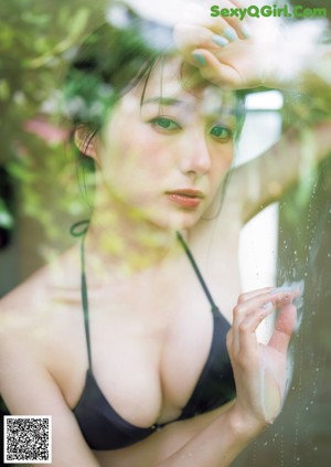 A woman in a bikini posing for a magazine cover.