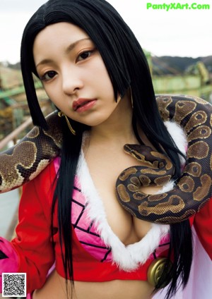 A woman holding a large snake in her hands.