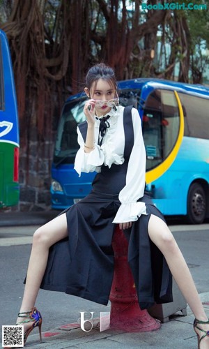 A woman in a white blouse and black skirt posing for a picture.