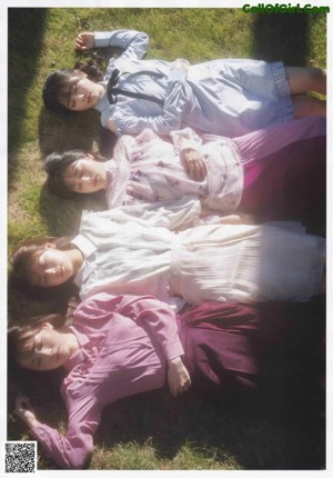 A group of young women standing next to each other in a field.