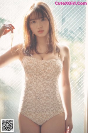A woman in a white dress standing in the grass.