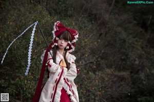 A woman in a red and white dress holding a fan.