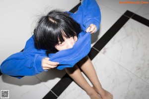 A woman in a blue bodysuit posing for a picture.