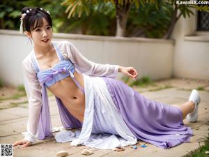 A young girl in a blue and pink hanbok sitting on a bed.