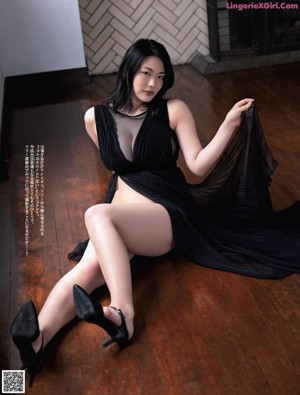 A woman in a blue lingerie standing by a window.