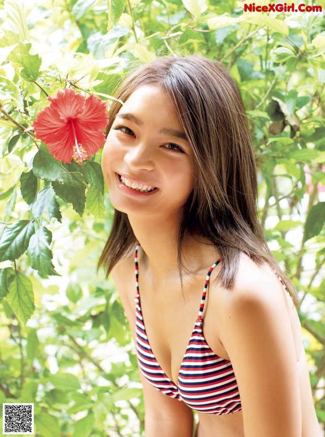 A woman in a red and white striped bikini posing for a picture.