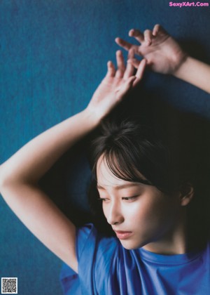 A woman in a blue dress sitting on the floor.