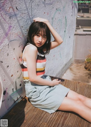 A woman in a blue dress sitting on the floor.