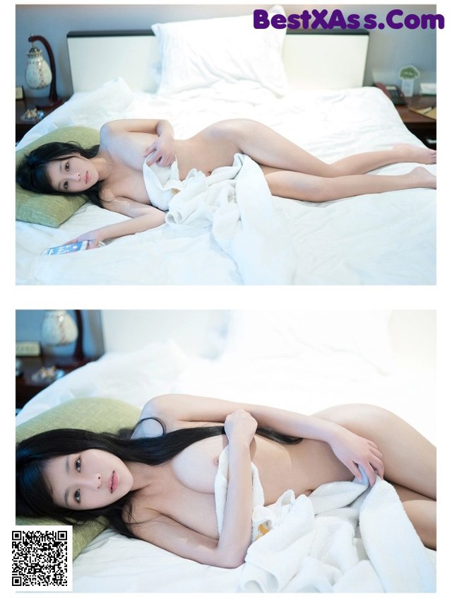 A woman laying on top of a bed covered in a blanket.