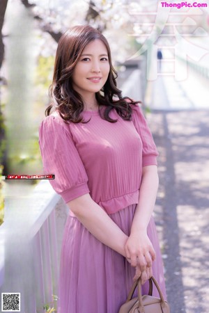A woman in a pink sweater posing for a picture.