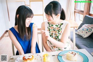 Two young women are playing with soap bubbles in the yard.