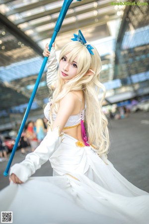 A woman in a white outfit holding a blue sword.