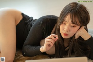 A woman laying on top of a bed with her feet up.