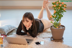 A woman laying on top of a bed with her feet up.