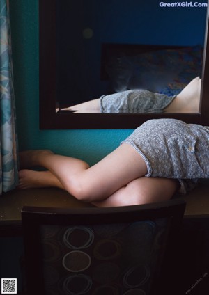 A woman laying on a bed in front of a mirror.