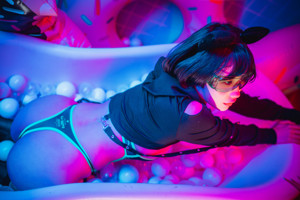 A woman sitting on top of an inflatable donut in a bathroom.