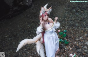 A woman in a white lingerie sitting in the water.